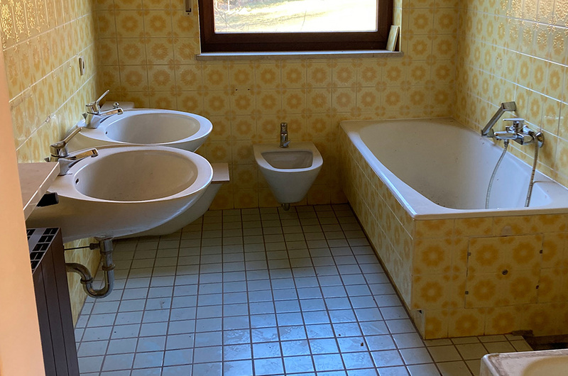 Altes Bad mit Blümchenfliesen und Duschtasse